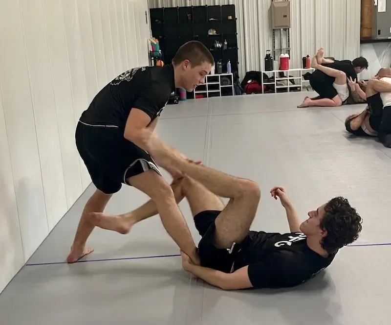 Adults training Brazilian Jiu-Jitsu with a partner.